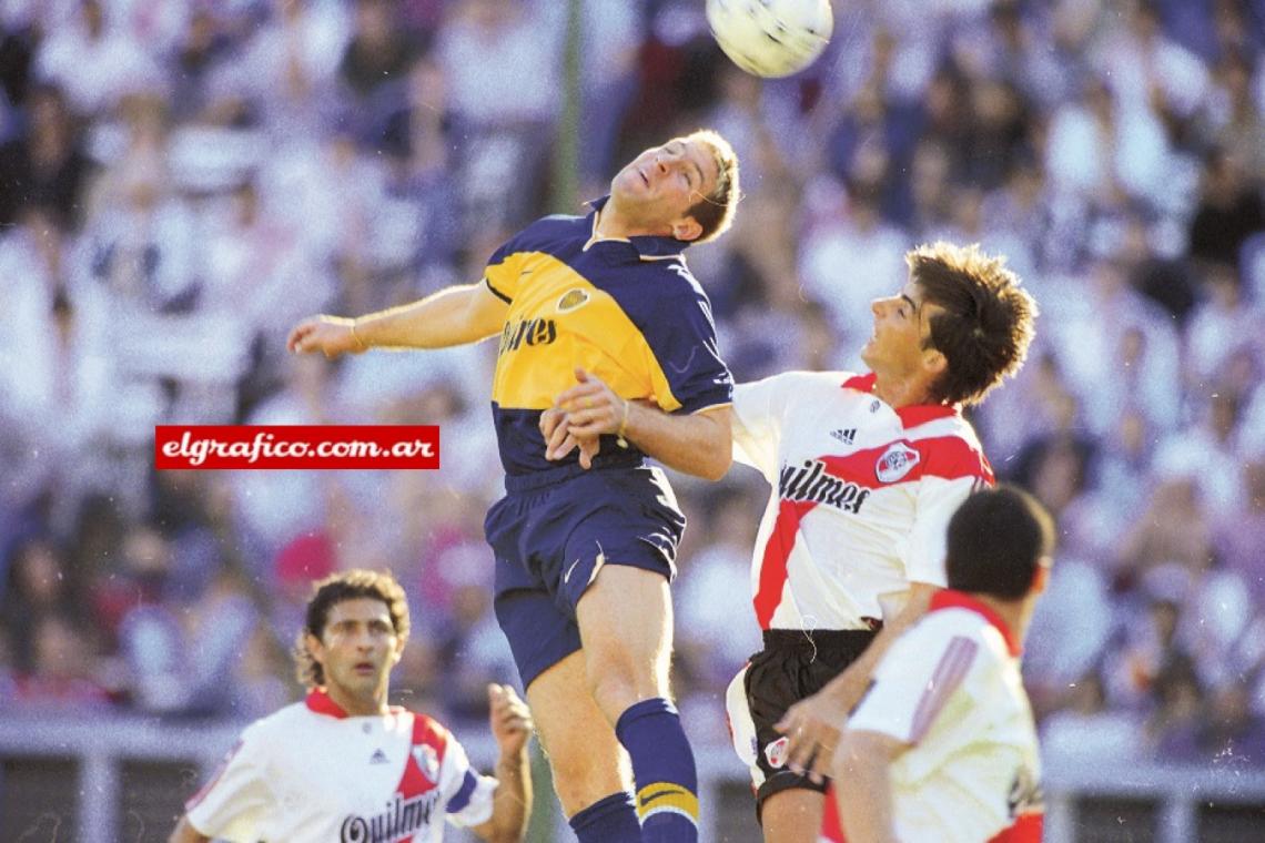 Imagen Martín Palermo salta seguido de cerca por el implacable Roberto Trotta. El Cabezón cumplió una buena tarea en la anulación de la principal carta ofensiva de Boca. Esta vez el goleador no pudo.