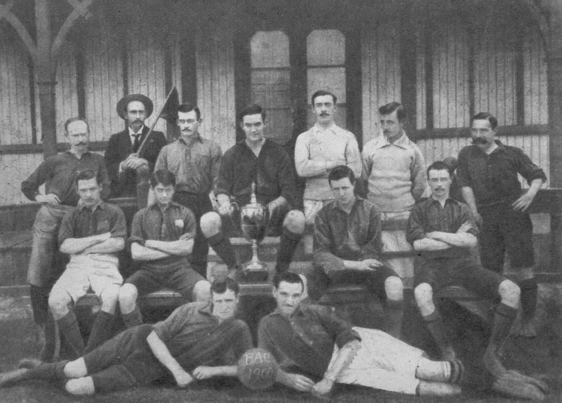 Imagen Team que en 1900 ganó la Copa de Honor, la primera vez que se instituyó ese trofeo con el cual aparece fotografiado. Parados: H. T. Ratcliff, J. R. S. Foz (linesman), E, P. Duggan, A. Addicott (capitán), R. Barker, C. E. Dickinson; y H. Creaven. Sentados: J, W. Baldock, W. Malm, Y. A. Coe, N. Dickinson. Acostados: F. W. Wibberley y G. L. Mac Farline.
