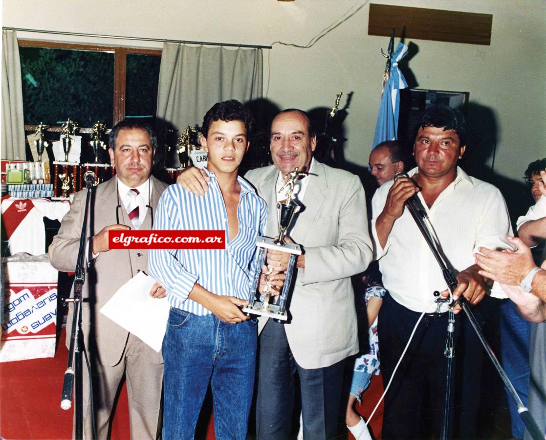 Imagen En River aprendió a levantar trofeos desde muy pequeño, como se ve en esta foto junto a dirigentes de fútbol amateur.