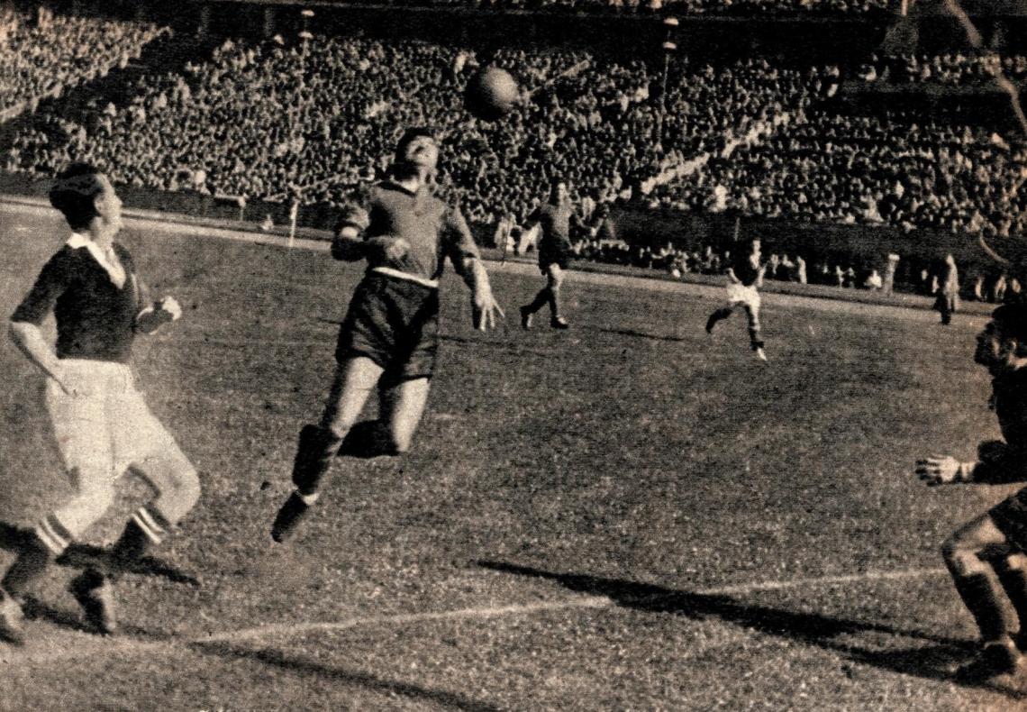 iQué demostración de "limpieza" en todos sus aspectos nos da esta foto! Sin alambrados altos como previsión; orden en la ropa de los jugadores y en las tribunas. Un solo particular al costado de la cancha, el césped parejo y bien cortadito. Uno se imagina el sol, unía pelota nueva iY una invitación a correr, a jugar!..