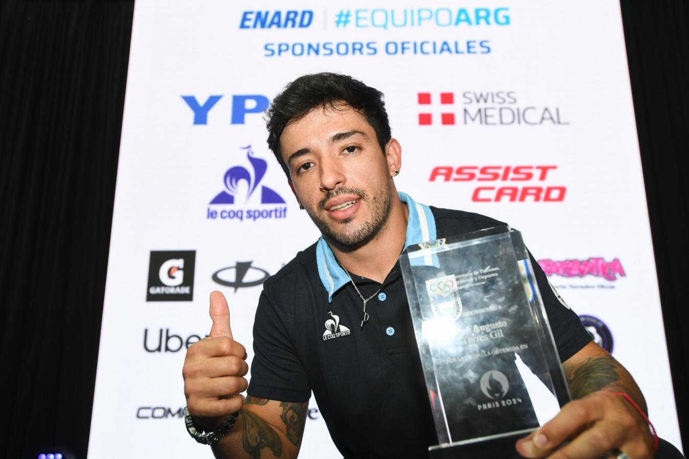 Imagen El Maligno con una plaqueta de reconocimiento por su oro olímpico