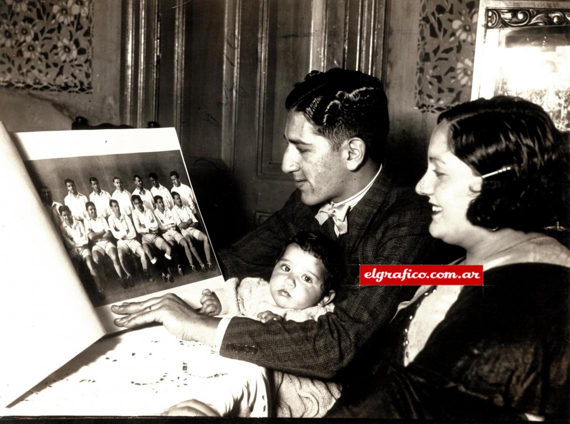 Imagen Evaristo Barrera, su señora esposa y la hijita frente a la lámina de El Gráfico, en la que apareció el primer team de Racing de 1933.