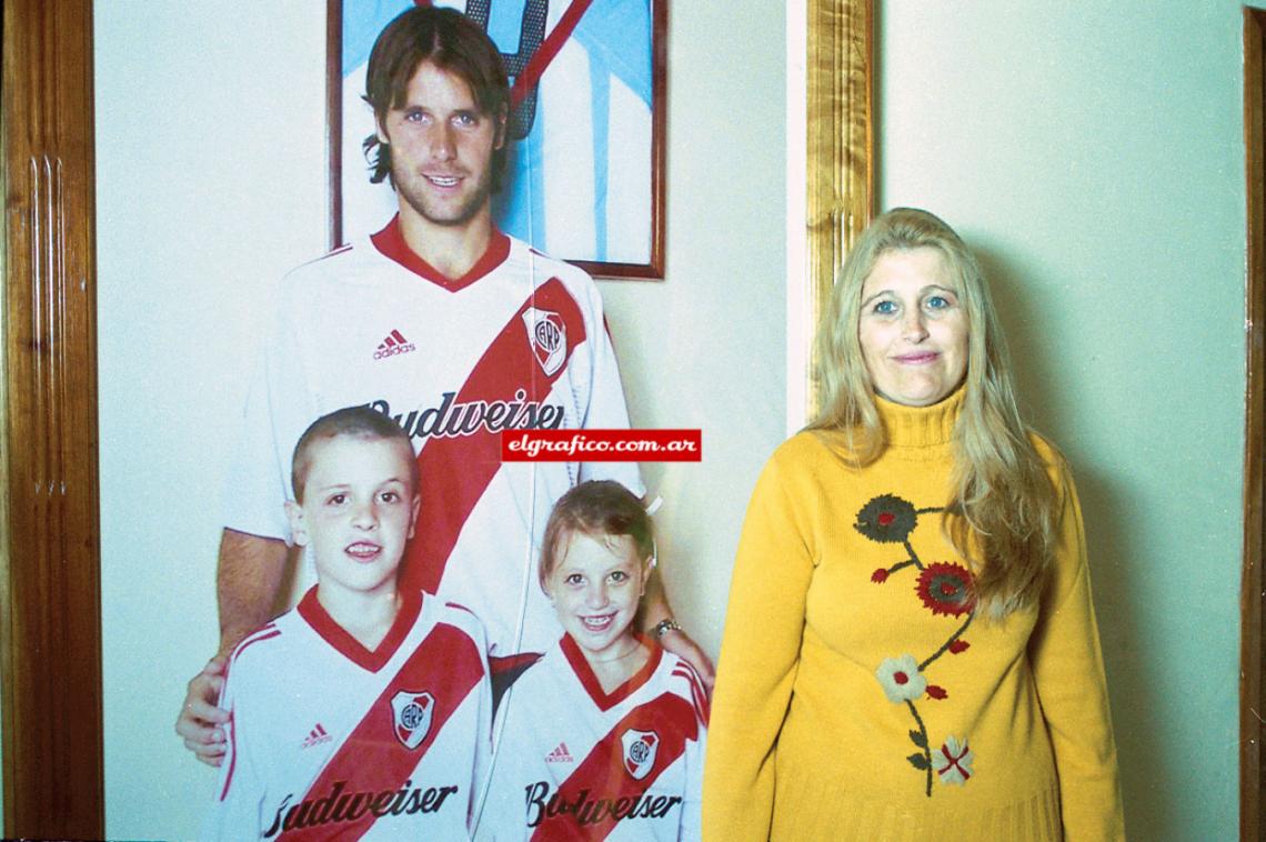 Imagen Mamá Mónica con la gigantografía de sus tres hijos.