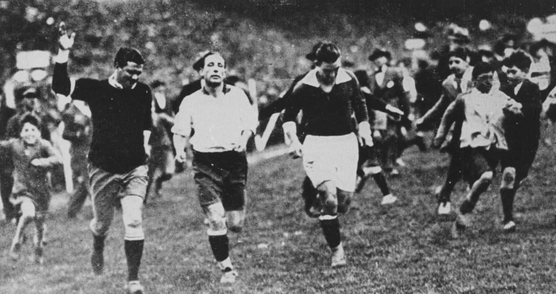 Imagen LA ÚLTIMA VUELTA. En un match de 1934 entre argentinos y uruguayos, el público homenajea cariñosamente a Seoane mientras da la vuelta al field junto a Minella y Gestido.