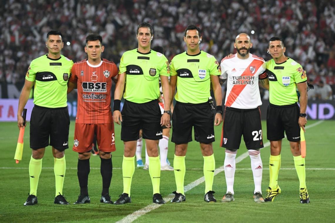 La terna arbitral junto con los capitanes. Javier Pinola y Cristian Vega.