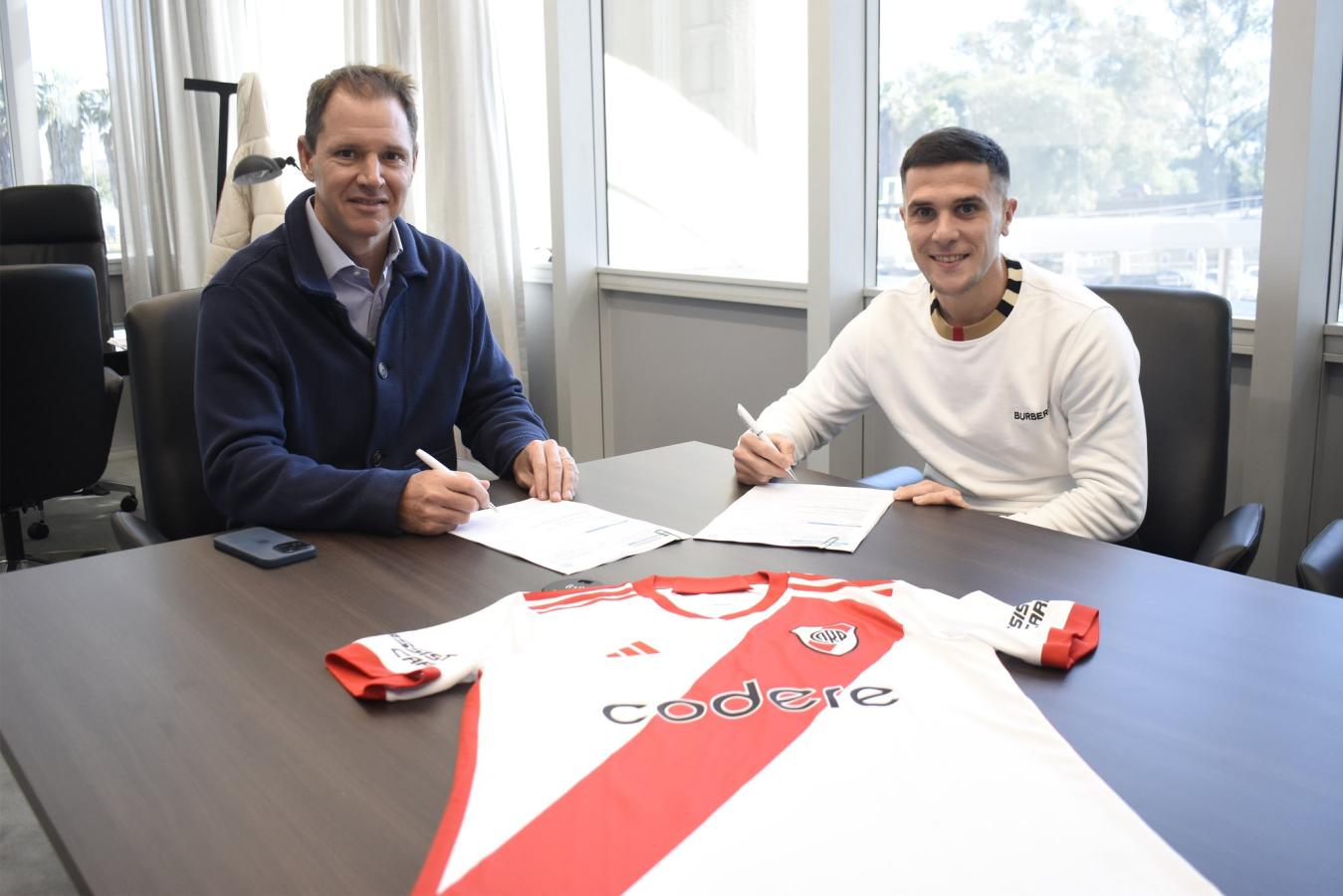 Imagen Fabricio Bustos y Jorge Brito al momento de la firma del contrato hasta 2027 por parte del futbolista. Foto: Prensa CARP