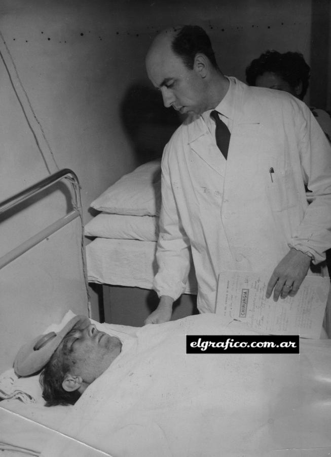 Imagen Juan Manuel Fangio en el hospital de Monza asistido por el doctor Carlos Parenti. Luego de unos primeros momentos sumamente inciertos y no del todo optimistas, la salud del campeón mundial ha ido mejorando sensiblemente hasta quedar fuera de peligro, aunque no puede adelantarse cuándo volverá a actuar en las pistas. 