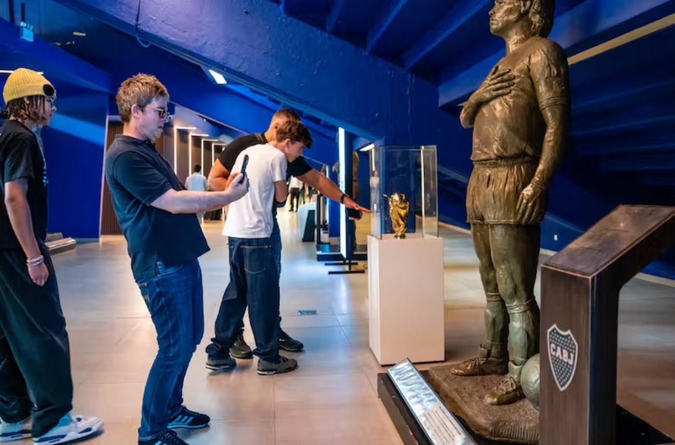 Imagen Noel Gallagher, en la Bombonera junto a la escultura de Maradona.