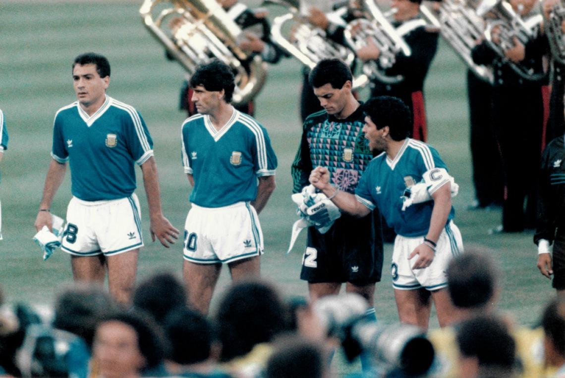 Imagen Antes de la final del mundo de Italia 1990 el himno argentino es silbado en el estadio Olímpico. Argentina venía de derrotar sorpresivamente a la selección local por penales. El capitán Maradona levanta el puño, a su lado Goycochea, Simón y Serrizuela. 