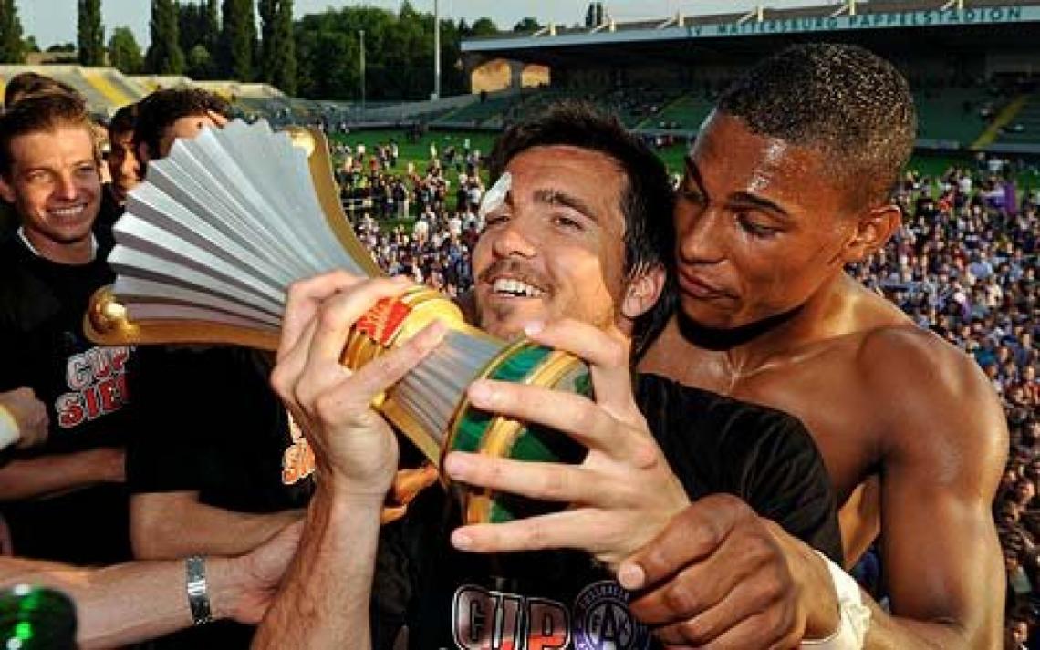 Imagen ABRAZO TRIUNFAL con su ex compañero Rubin Okotie. Levanta una de las tantas Copas que ganó.