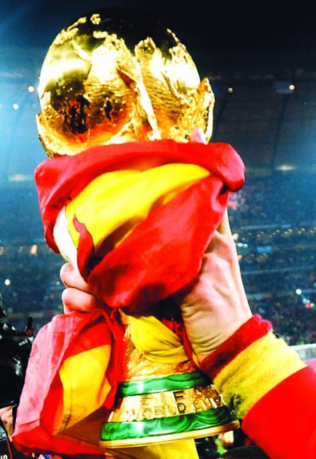 Imagen LA COPA envuelta en la bandera española, en la noche de Soccer City. España dejó un estilo a imitar y lo refrendó con el título (Foto: AFP).