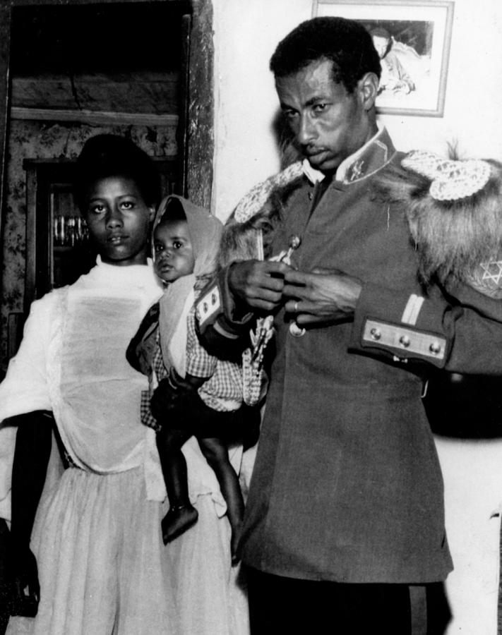 Imagen EN FAMILIA. Bikila se acomoda el uniforme de la Guardia Imperial, mientras que su esposa sostiene en brazos a su hija Teege de 18 meses.