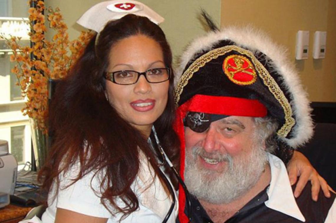 Imagen Aquí, Blazer posa junto una mujer disfrazada de enfermera. Él tiene un look similar a Papá Noel, pero personifica a un pirata.