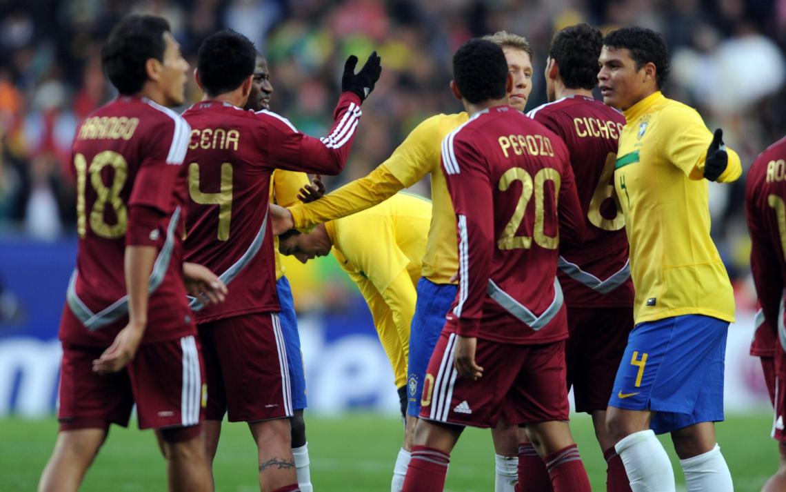Imagen MONTONERA.Lucas y Andre Santos protegen a Ganso. Los jugadores venezolanos le reclamaban falta de Fair Play. (AFP)
