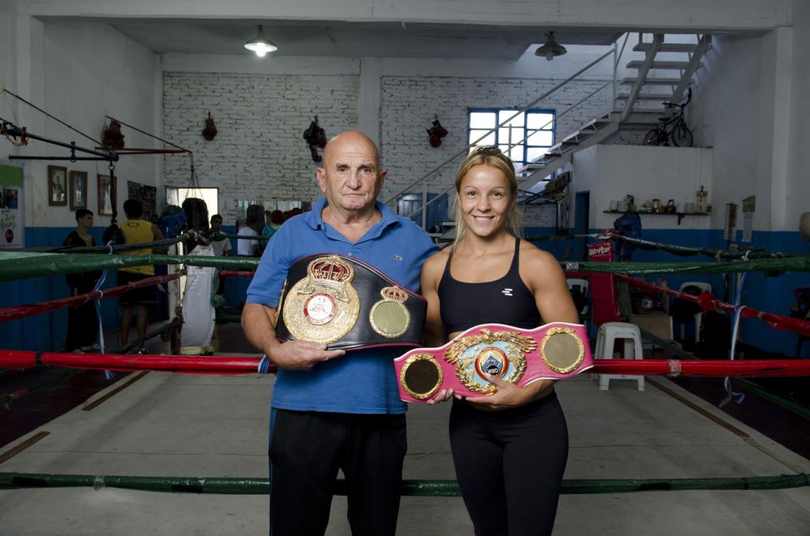 Imagen BINOMIO: Bopp junto a Delfino Pérez en el gimnasio donde arrancó la historia. El con el cinturón AMB; ella, con el de la OMB.