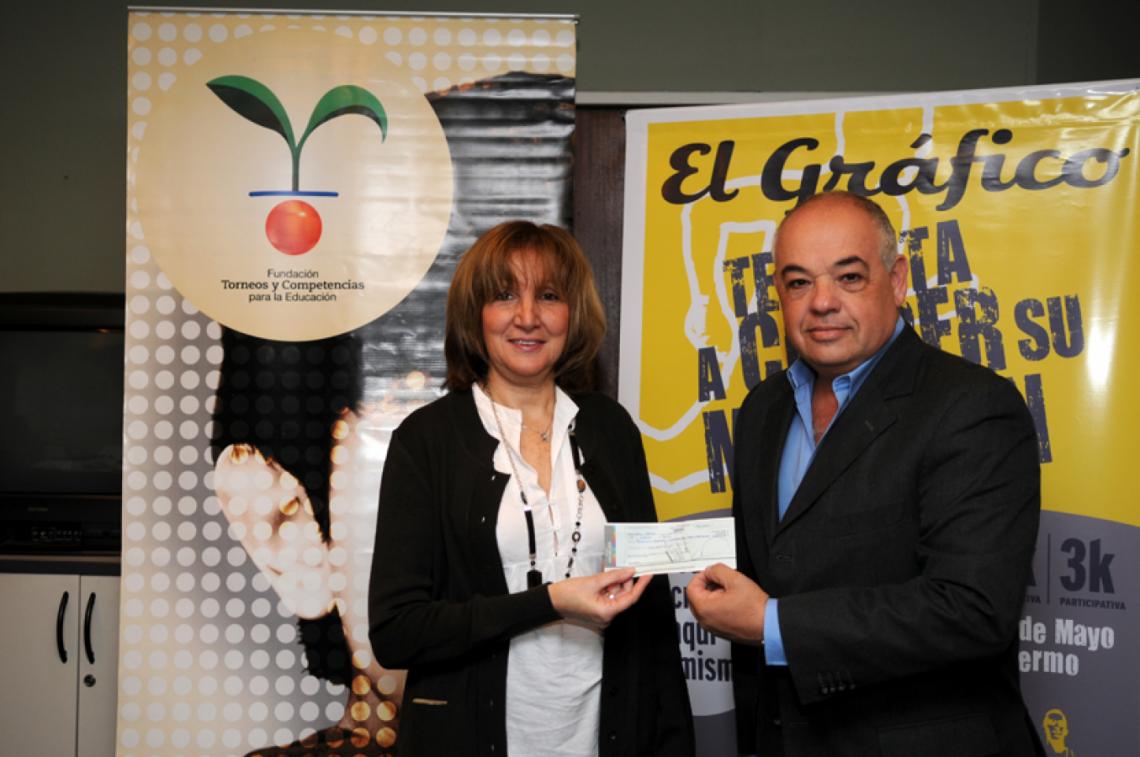 Imagen BEATRIZ Juárez de la Fundación Torneos y Competencias para la Educación, recibe el aporte de El Gráfico de manos de Carlos Lugano.