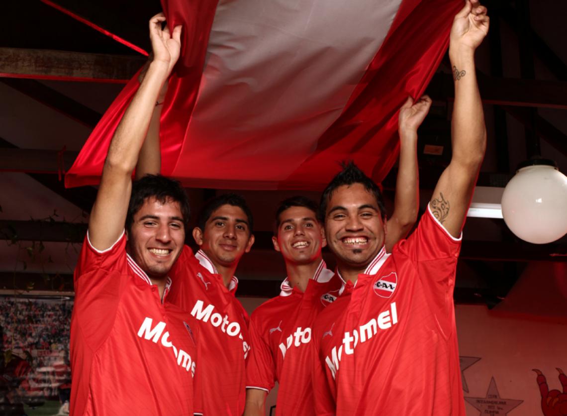 Imagen COMO EN la popular, Vidal, Monserrat, Patricio Rodríguez y Velázquez sostienen la bandera del fútbol en Independiente.