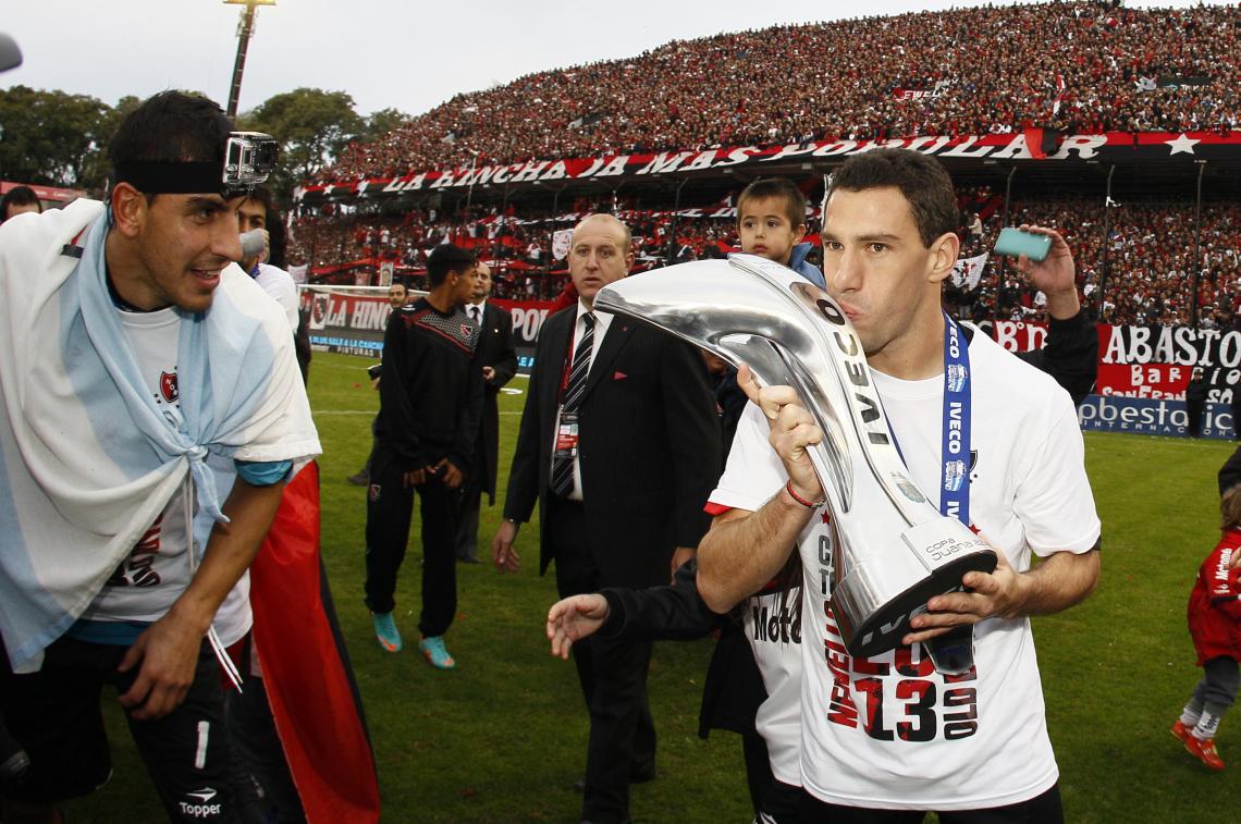 Imagen EL MOMENTO CULMINANTE de la celebración del título. Maxi besa la copa mientras el Pato Guzmán lo registra todo con su camarita. Maxi no había podido conseguirlo en su primer ciclo en el club, pero lo hizo ahora con 32 años. Aspira a retirarse en el club y