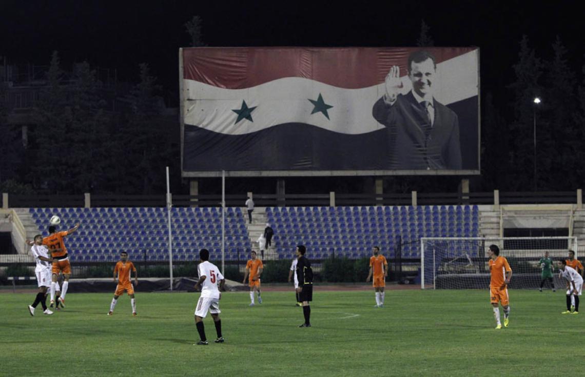 Imagen FUTBOL PARA NADIE: El afiche del dictador Assad, en Al Wahda-Al Jaish, con tribunas vacías.
