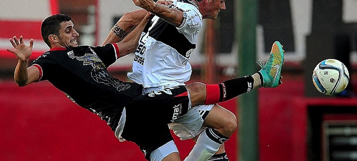 Imagen En la lucha. Típica acción de nuestras canchas, durante Huracán-Gimnasia.