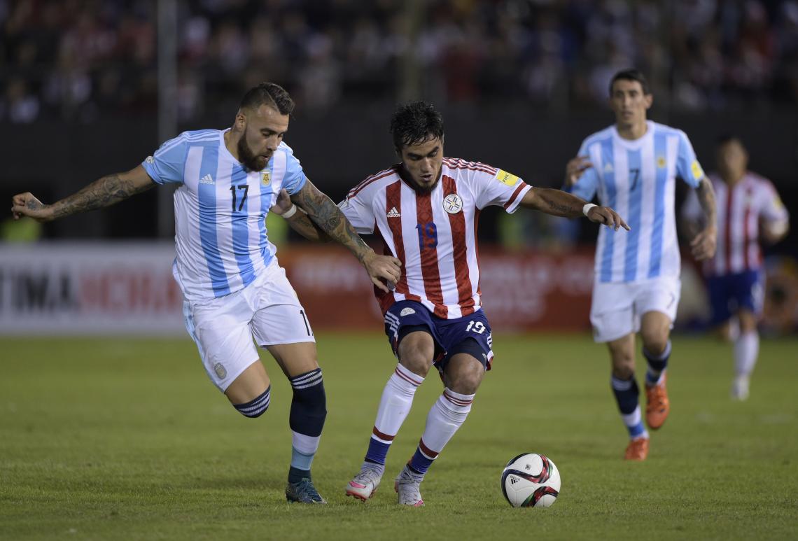 Otamendi en acción. Di María mira. Sin fútbol, Argentina sólo empató 0-0 ante Paraguay.
