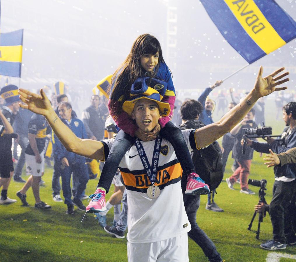 Imagen Con su hija -Camila- sobre sus hombros, celebra el primero de los dos campeonatos que consiguió en Boca. 