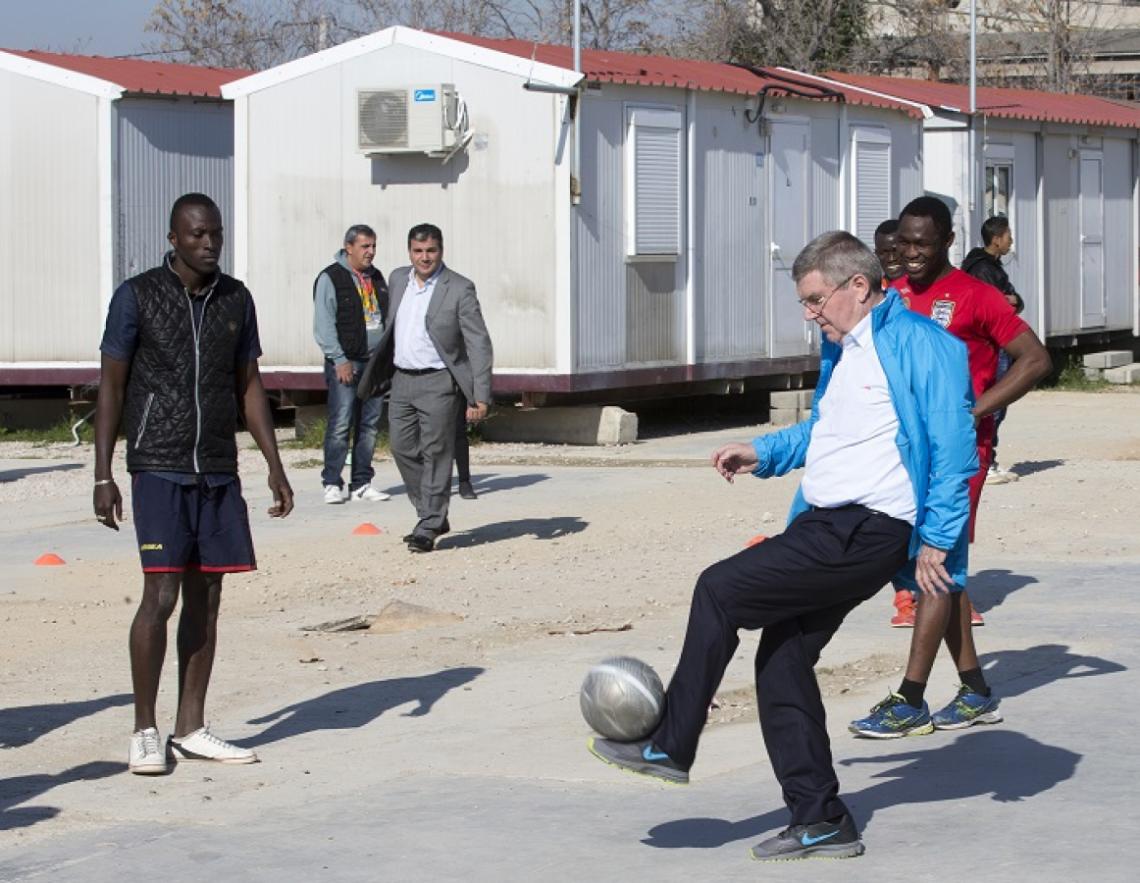Imagen THOMAS BACH, presidente del Comité Olímpico Internacional, juega al fútbol con los refugiados del campamento Eleona en Atenas.