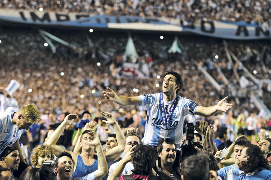 Imagen Hermosa postal del instante único de la vuelta olímpica. Racing acaba de ganar el Torneo Transición 2014. En su primer campeonato tras el regreso, se dio el gusto: fue fundamental con sus goles (6) y contagio.