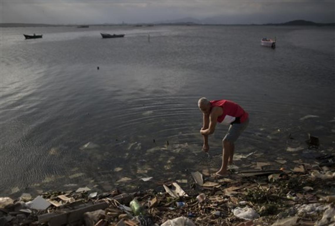 Imagen Un hombre se limpia en las aguas contaminadas de la Bahía Guanabara en Río de Janeiro, Brasil, el sábado 30 de julio de 2016. Aunque las autoridades locales, entre ellas el alcalde de Río, Eduardo Paes, han reconocido el fracaso de la ciudad en sus accion