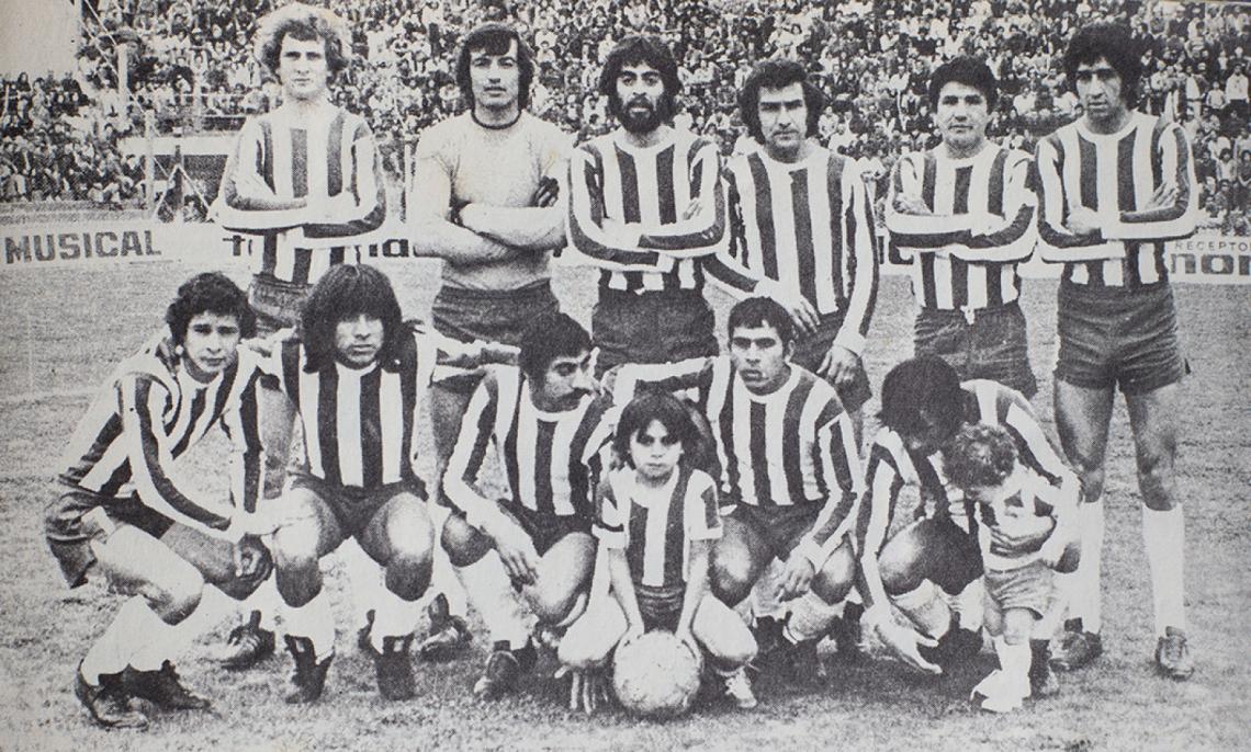 Otra vez mascota, ahora con todo el equipo, con la pelota en sus manos, entre el Ojudo Patire y Antonio Rosa Alderete.