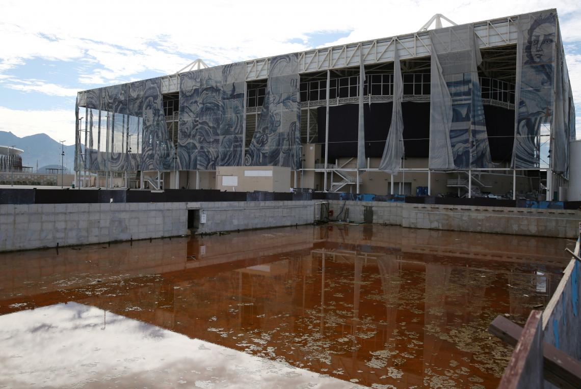 Imagen Vista del Estadio Olímpico Acuático, los cráteres de las piscinas desmontadas recogen el agua estancada.