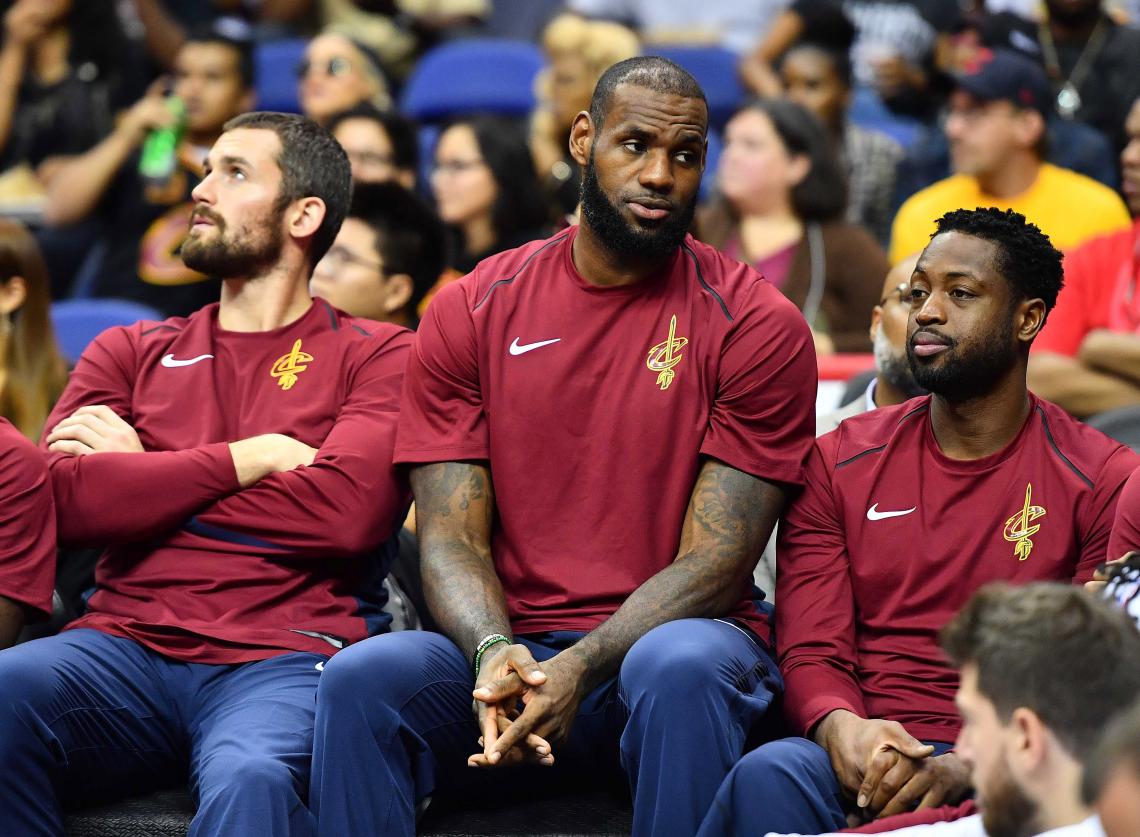 Imagen LeBron, observando un partido con Love y Wade.