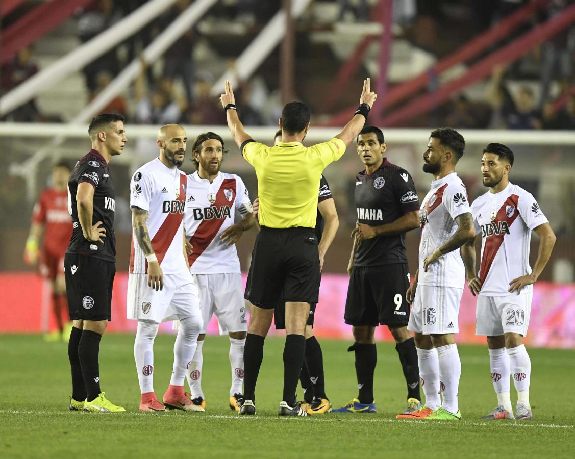 Imagen El árbitro Roldán, rodeado por los jugadores de River y Lanús.