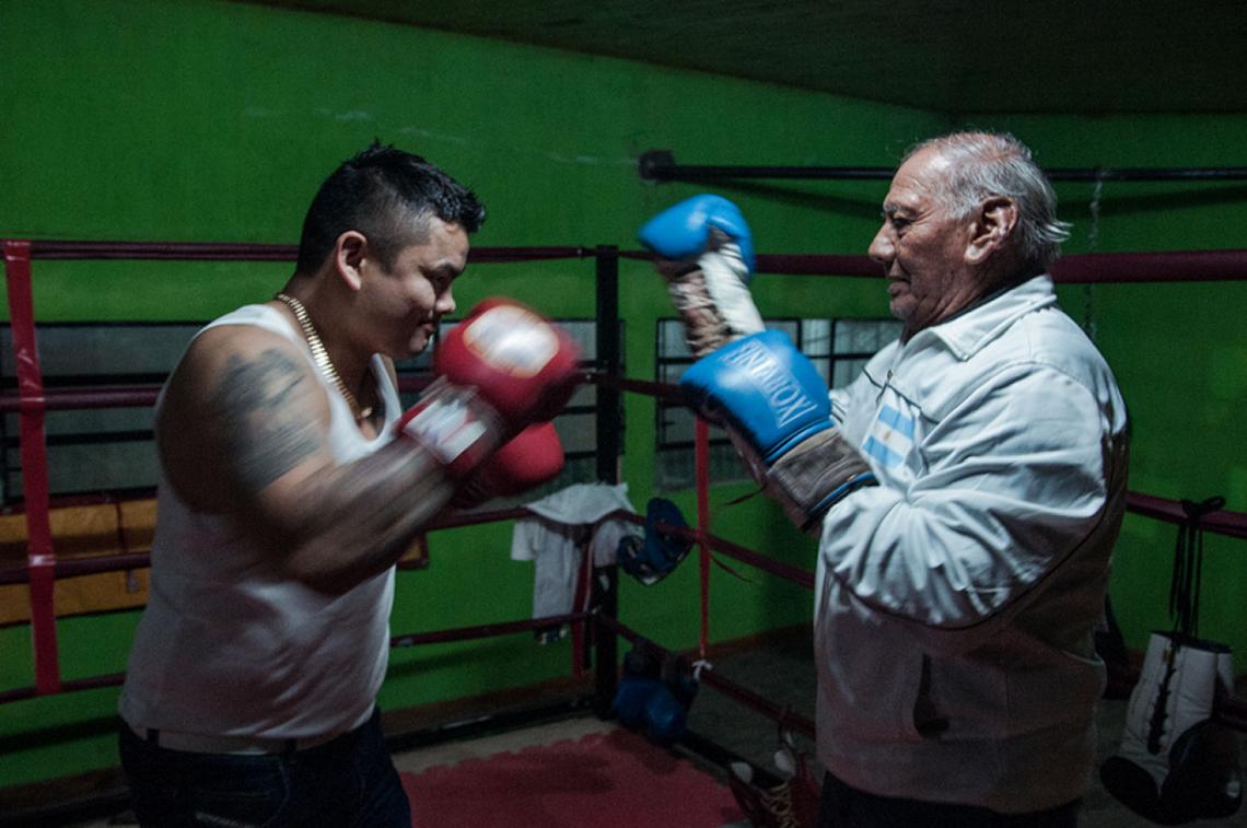 Imagen El Chino haciendo guantes con Ricardo Linari, su primer entrenador, en el ring que armó en el segundo piso de sus canchas de fútbol 5.
