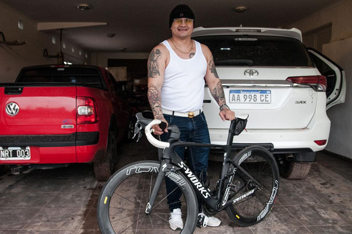 Con la bici que utiliza cada año para la travesía de 500 kilómetros hasta Itatí, para visitar a la virgen. Atrás, sus dos camionetas.