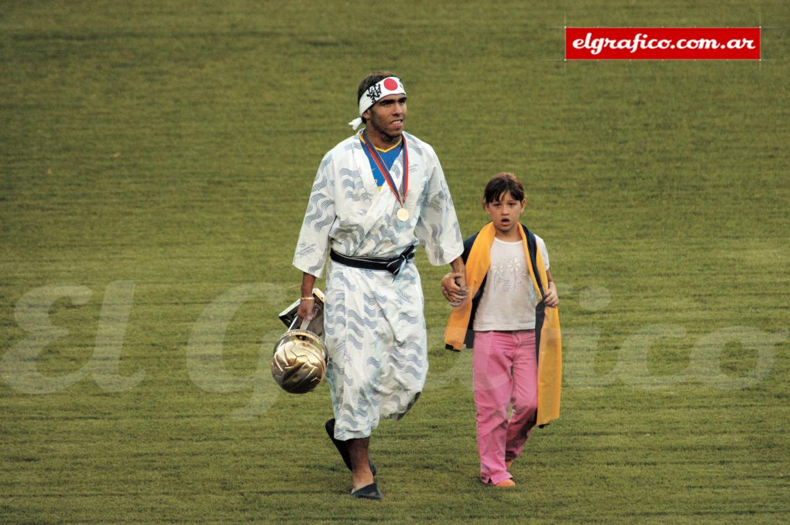 Imagen Tévez con kimono, vincha y copa junto a su hija Flor. 2003, regreso feliz.