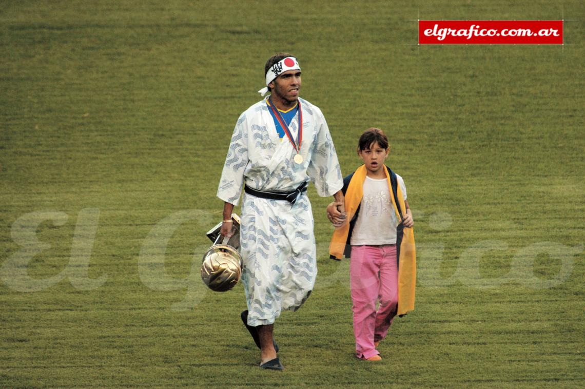 Tévez con kimono, vincha y copa junto a su hija Flor. 2003, regreso feliz.