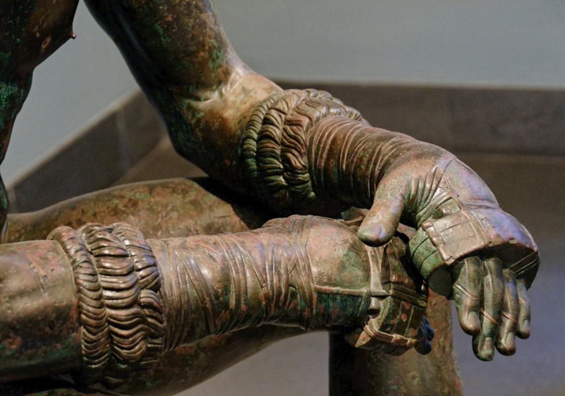 En este detalle de una escultura griega del Siglo IV a.C, se observa los Cestos, correas que usaban arrolladas en las manos los antiguos “pugilistas” para reforzar el golpe.