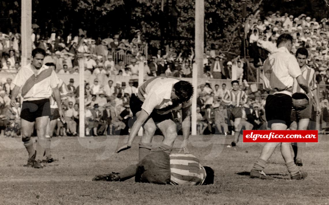 1957. En su segunda etapa en River "charlando" a un jugador de Estudiantes que acaba de derribar.