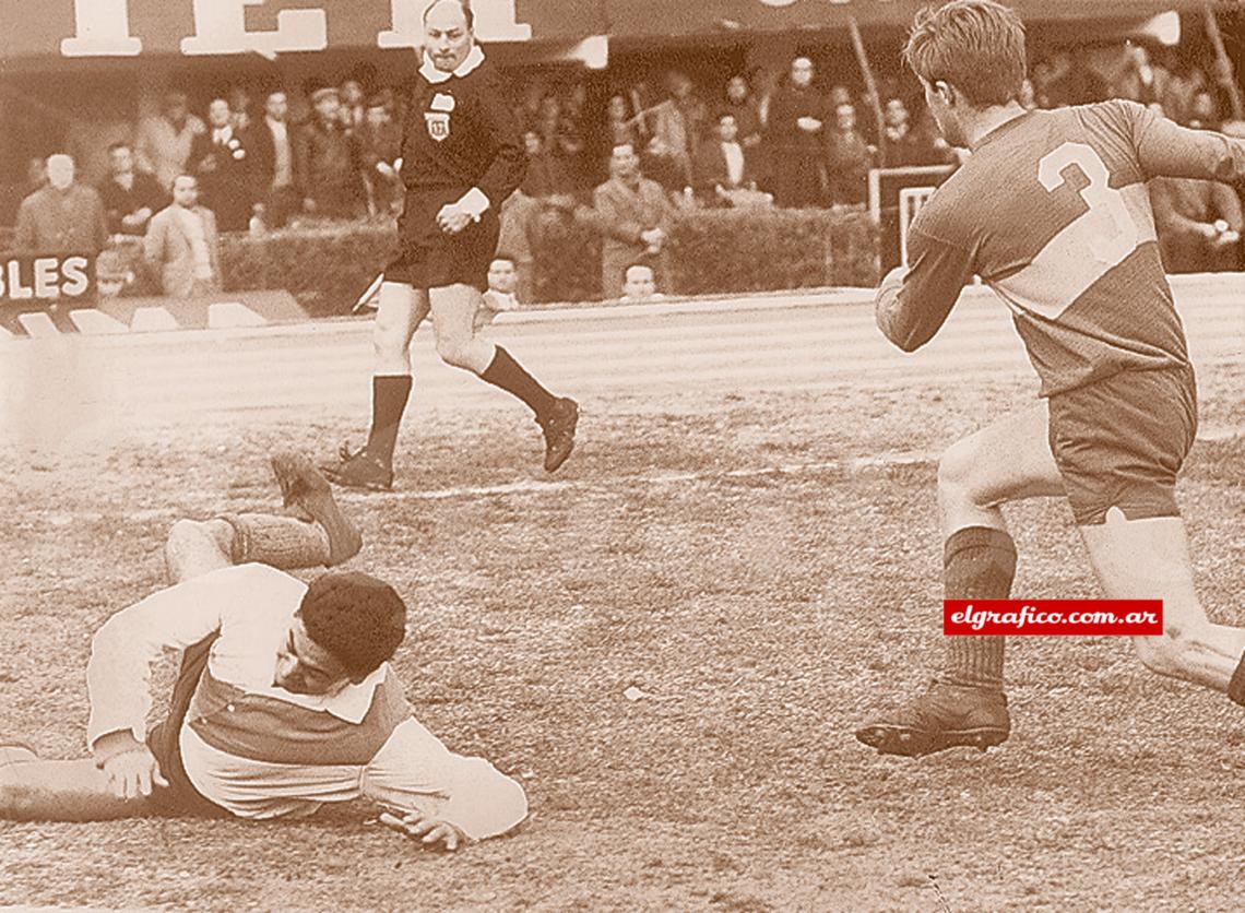 Imagen El uruguayo por el suelo; el de Boca, de espaldas, y la pelota fuera de escena.