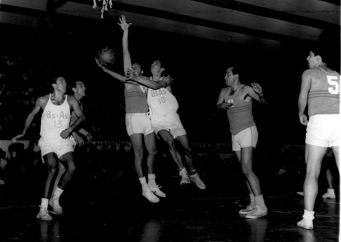 Imagen 1966. Final Campeonato Argentino de Básquet: Buenos Aires 82 - Córdoba 72. Fruet, todo nervio, entra en bandeja tapado por Hugo Oliva. Barrenche y Hugo Olariaga están por entrar en acción.