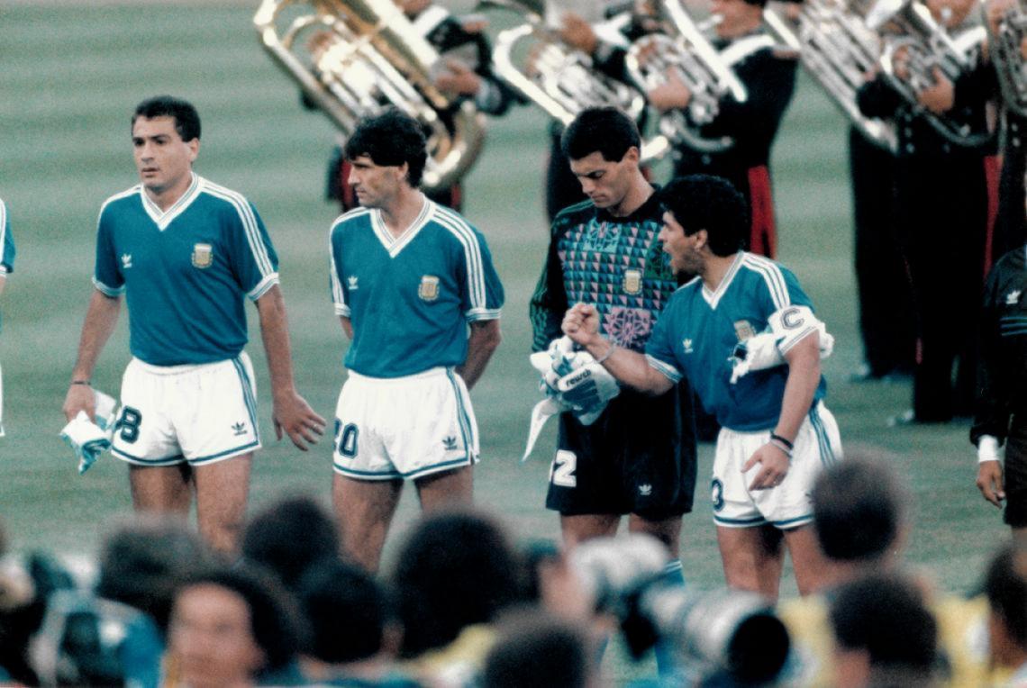Antes de la final del mundo de Italia 1990 el himno argentino es silbado en el estadio Olímpico. Argentina venía de derrotar sorpresivamente a la selección local por penales. El capitán Maradona levanta el puño, a su lado Goycochea, Simón y Serrizuela.