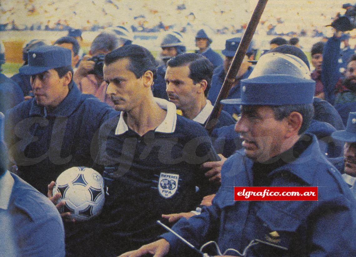 El árbitro deja el campo de juego rodeado y custodiado por la policía. Las protestas comenzaron por la sanción de un penal a favor de River. Nada justifica el terror.