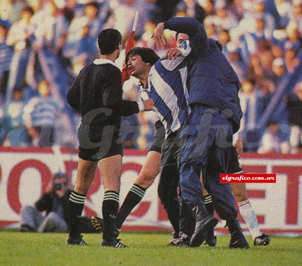 Imagen Un minuto después, cuando el juego ya se había reanudado, un vándalo ingresa al campo de juego para agredir al árbitro Javier Castrilli. Lo empuja.