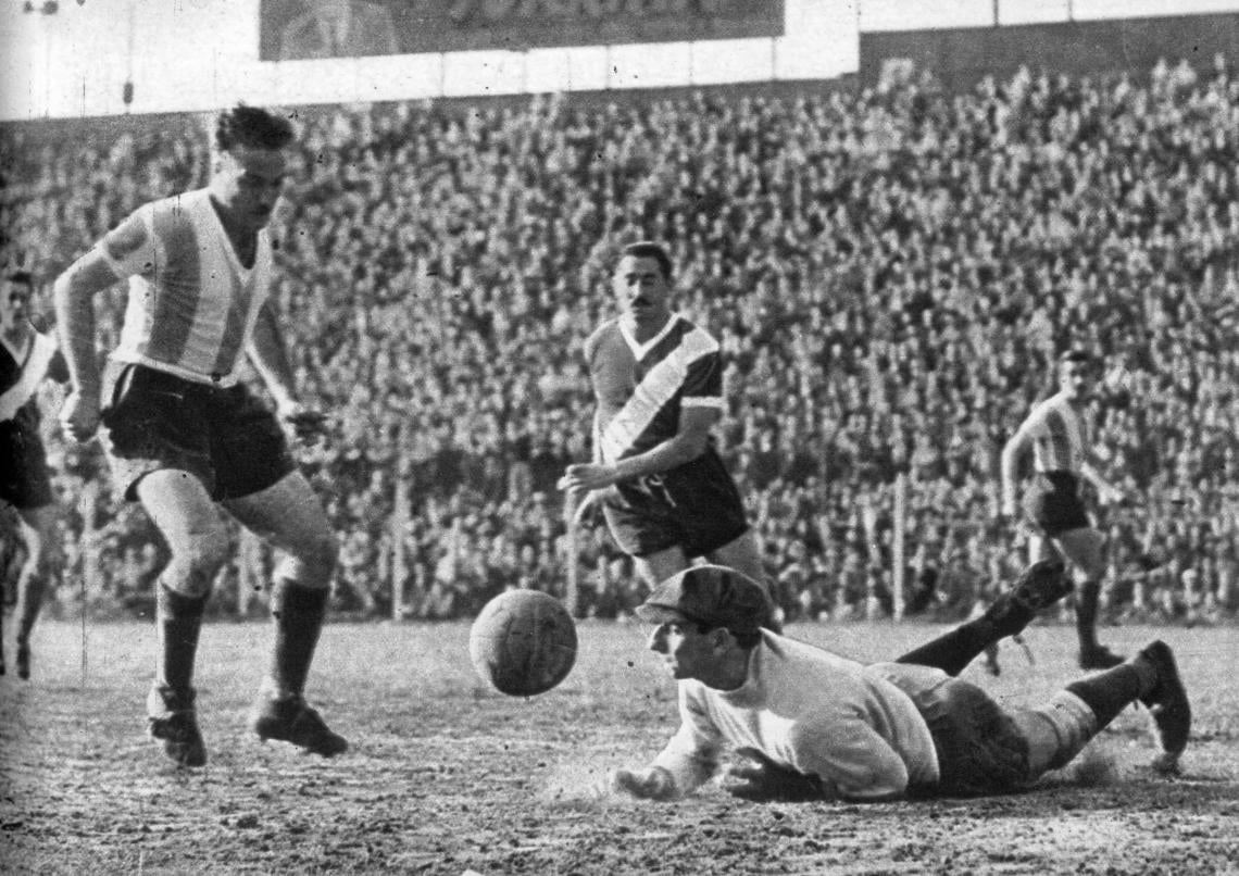 Con visible esfuerzo ha detenido Grisetti un violento tiro de Moreno; el zaguero García acude en su ayuda para que pueda recuperar la pelota.