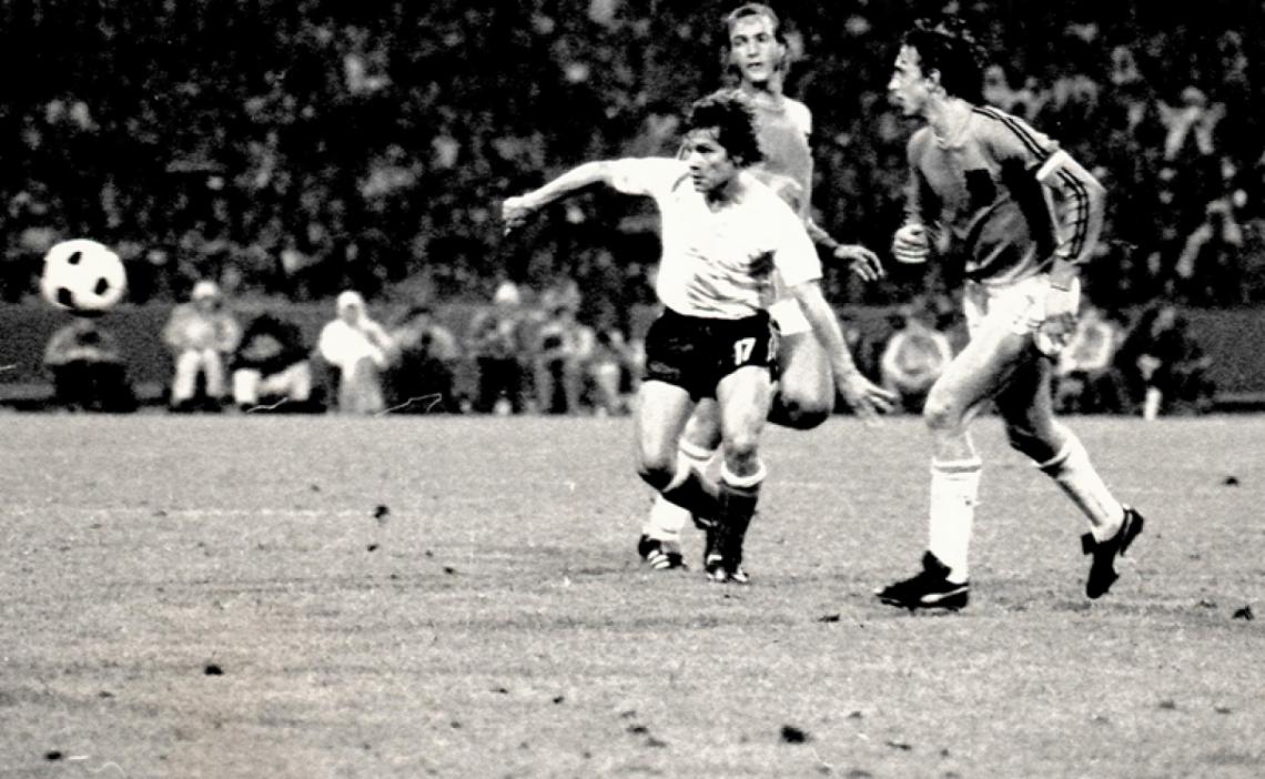 Imagen “Y la pelota. Nada más que la pelota. Esa que empieza como juguete, como alegre diversión. La pelota es inglesa, pero fue al Dock Sur, fue al baldío de Carlitos, fue a buscarlo, a ofrecerse…” (En la foto en el Mundial de Alemania 1974 enfrentando a Cruyff de Holanda).