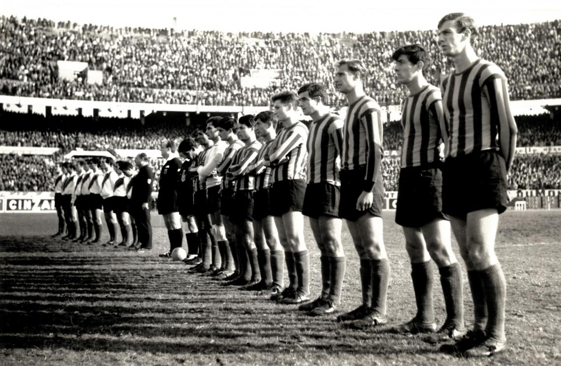 Imagen Antes del partido entre River Plate y Rosario Central, jugado el 12 de Mayo (Día del Himno) de 1963 se canta el “Oid mortales” en todo el Monumental. En primer término César Luis Menotti. Foto GONZALEZ