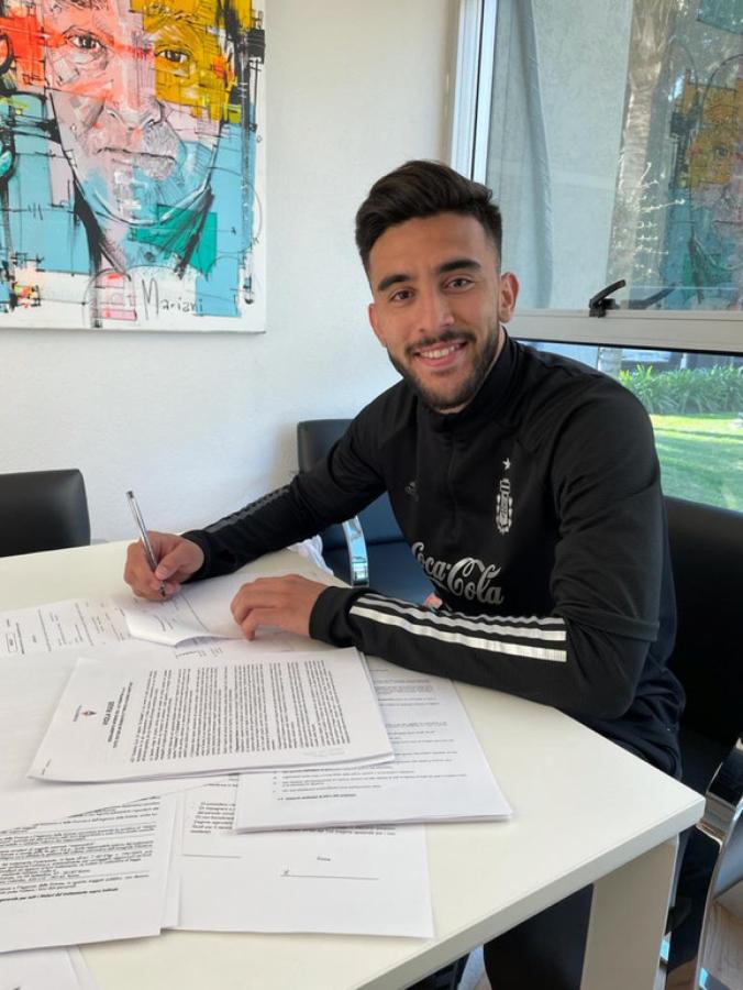 Nicolás González firmando el contrato en la concentración Argentina.