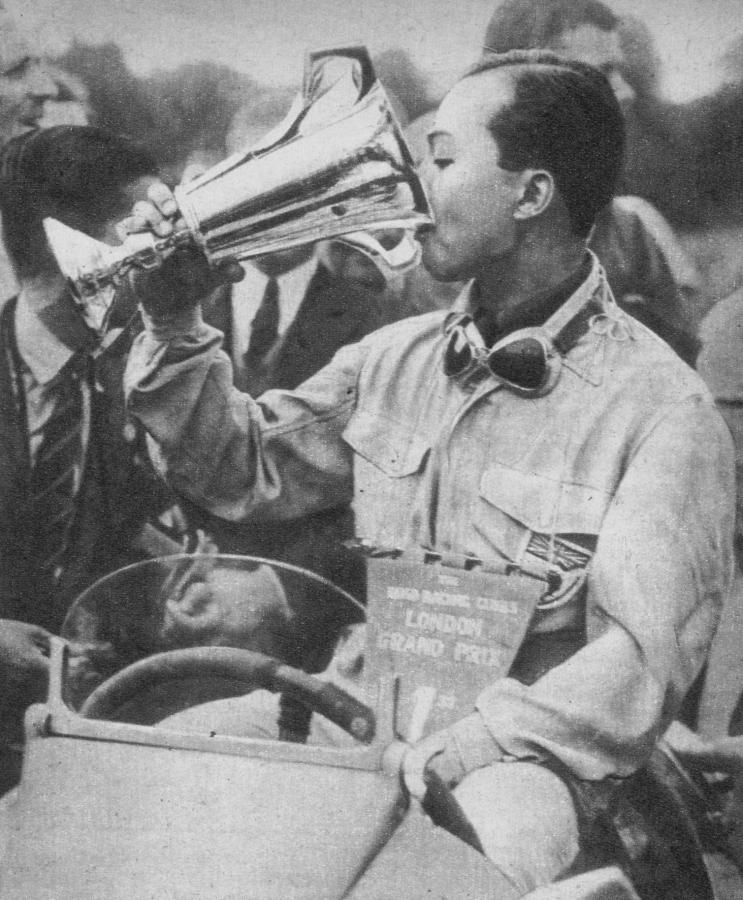 Imagen El príncipe de Siam, Birabougre, que corría el coche inglés E.R.Á. con el seudónimo de Bira, aparece en la presente fotografía luego de su triunfo en el Gran Premio de Londres corrido en el Crystal Palace en 1937. Festeja esa victoria a la usanza clásica de beber champagne en el trofeo obtenido. 