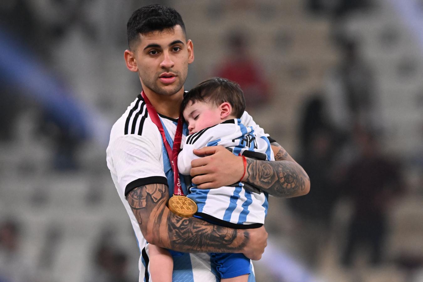 Imagen Cuti, la medalla de campeón y el Mini Romero en sus brazos. "Fue lo más lindo vivirlo al lado de él", admitió. Foto: AFP